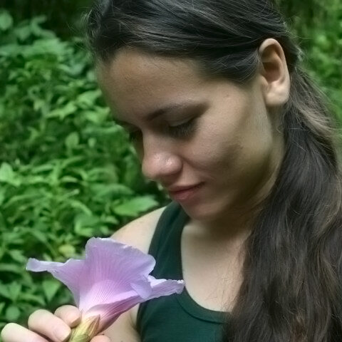 Marcela Leon of True Nature Travel holds flower while on yoga retreat.